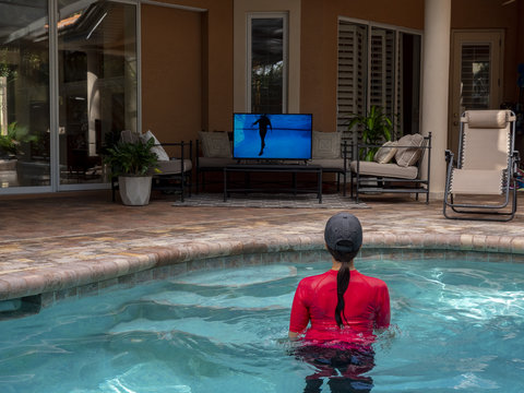 Person exercising in the pool with the Poolfit app. Exercise vigorously in the low imact environment of the pool. 